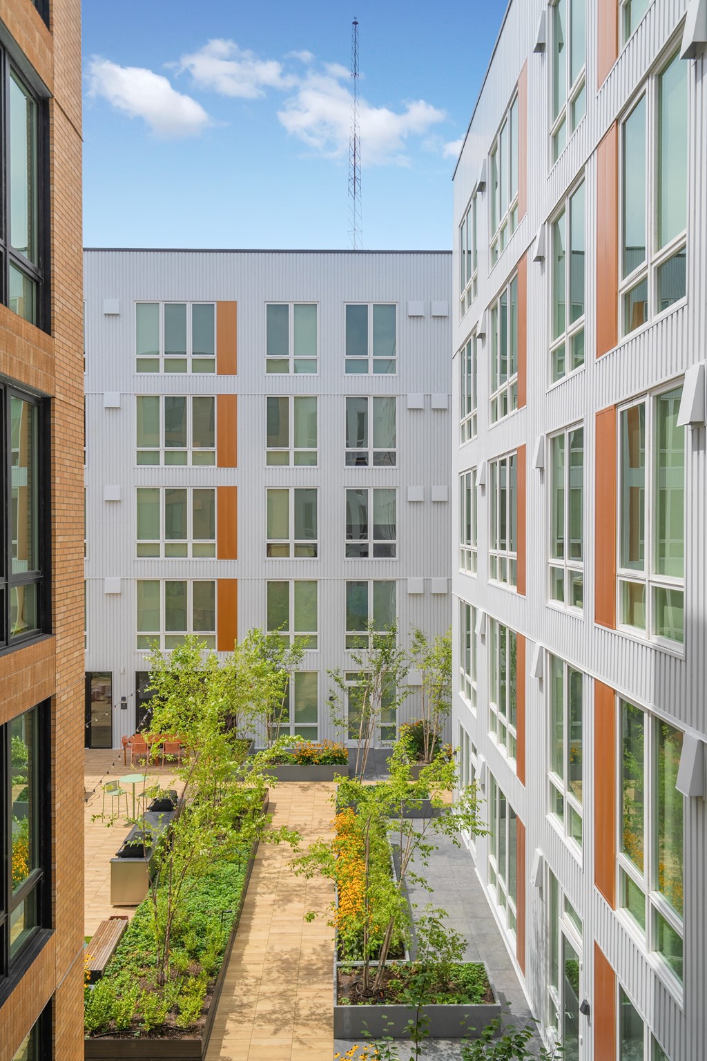 a courtyard with trees and plants in front of a building