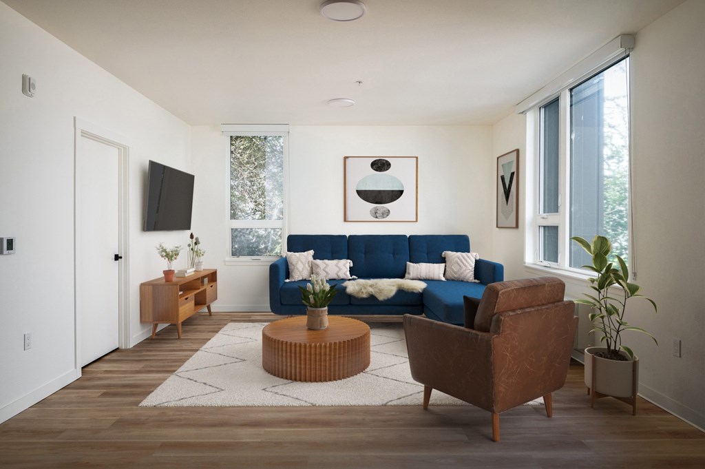 The Wes Gresham Oregon Apartments A living room with a blue couch, a brown armchair, and a wooden coffee table.