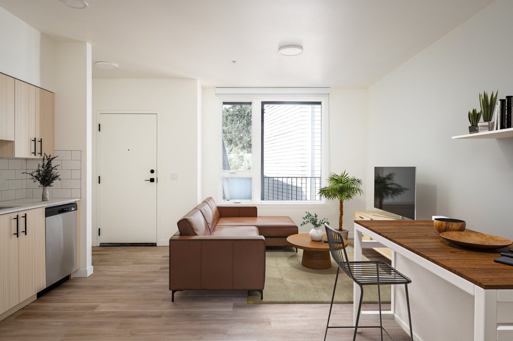 The Wes Gresham Oregon Apartments A modern living room with a brown couch and a white kitchen area.