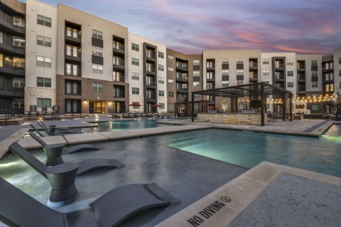 A modern building with a pool in front and a