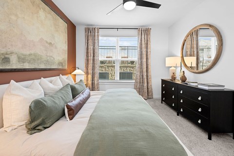 A bedroom with a large bed and a painting on the wall.