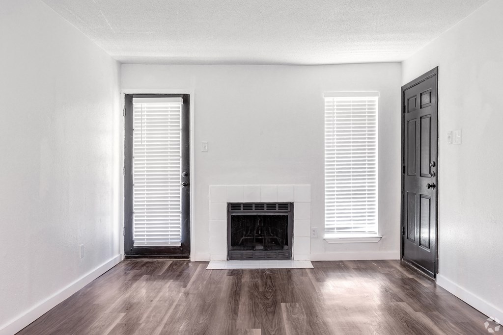 an empty living room with white walls and a fireplace
