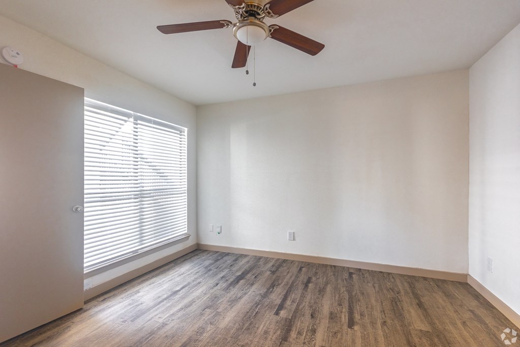 The Beckham Apartments living room with a large window and a ceiling fan