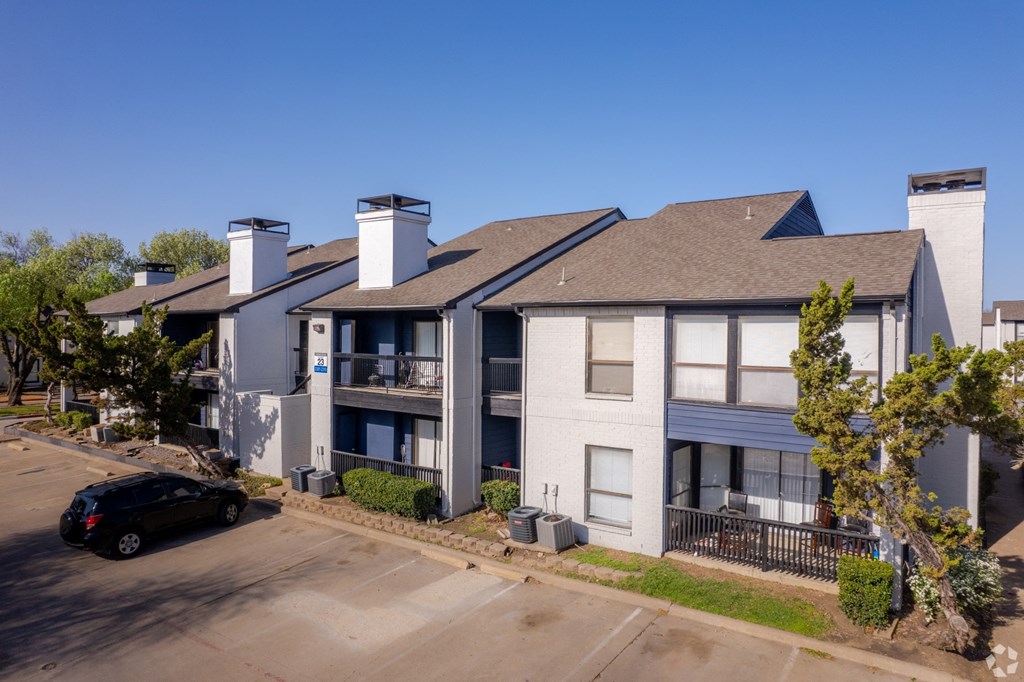 an aerial view of an apartment building with a car parked in front of it