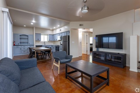 A living room with a grey couch and a black coffee table.