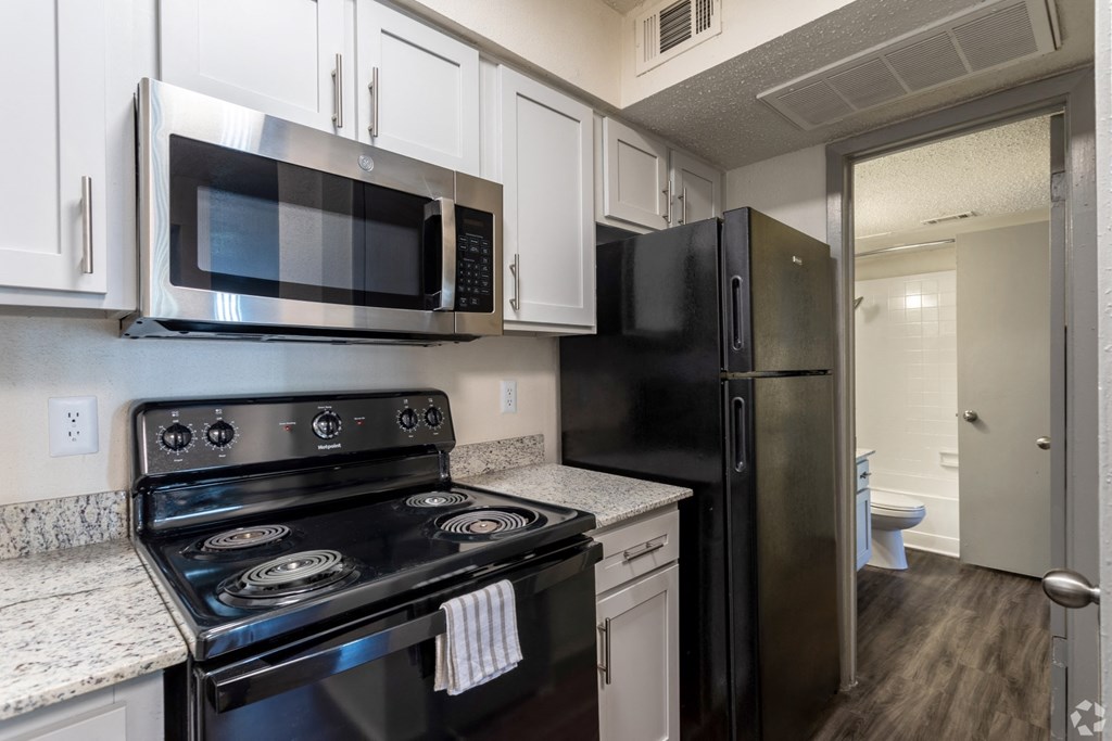 a kitchen with stainless steel appliances and white cabinets
