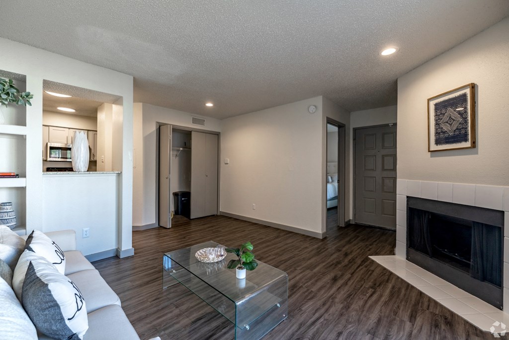 a living room with a fireplace and a glass coffee table