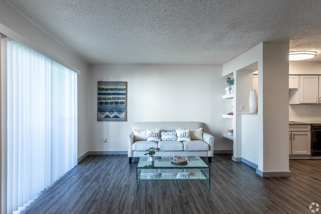 a living room with a white couch and a glass coffee table