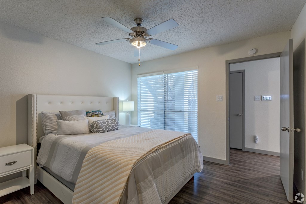 a bedroom with a bed and a ceiling fan