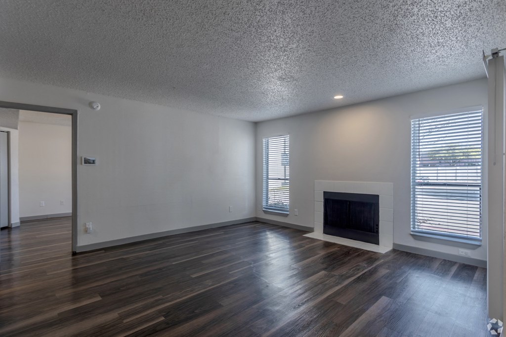 the living room of an empty house with a fireplace