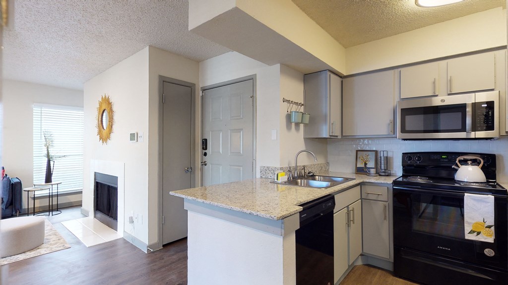 a kitchen with a granite counter top and black appliances