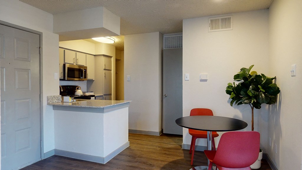 an apartment kitchen and dining area with a table and chairs
