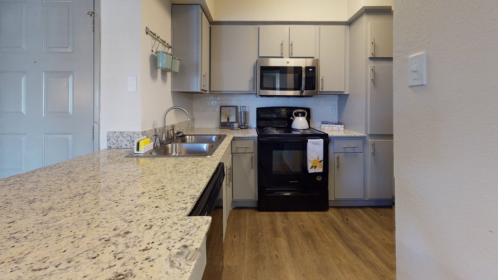 a kitchen with granite counter tops and white cabinets
