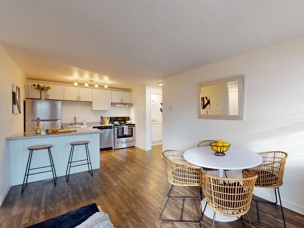 a living room with a table and chairs and a kitchen