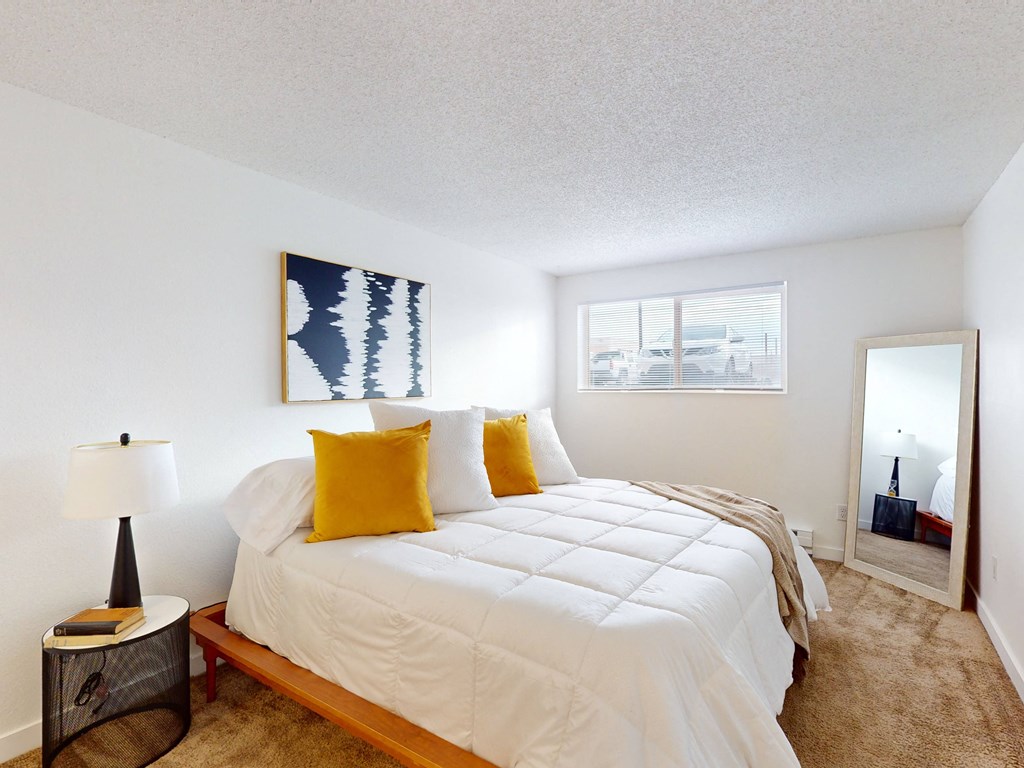 a bedroom with a large bed and a mirror