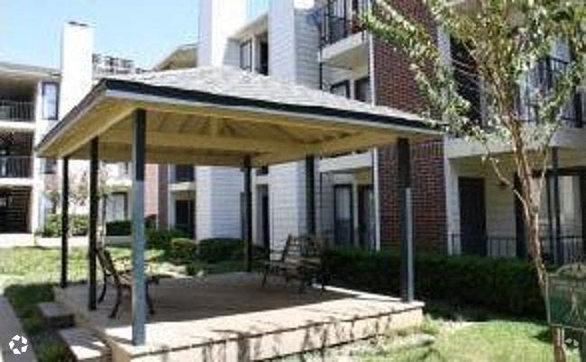 a patio with a pavilion in front of an apartment building