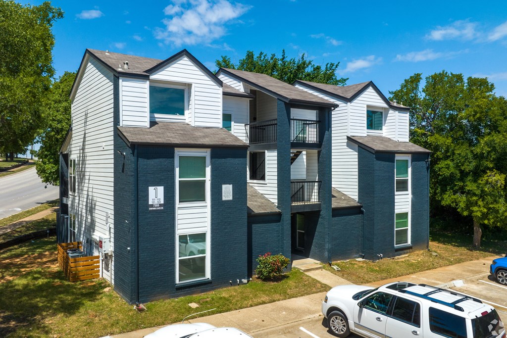 an apartment building with three stories and a van parked in front of it