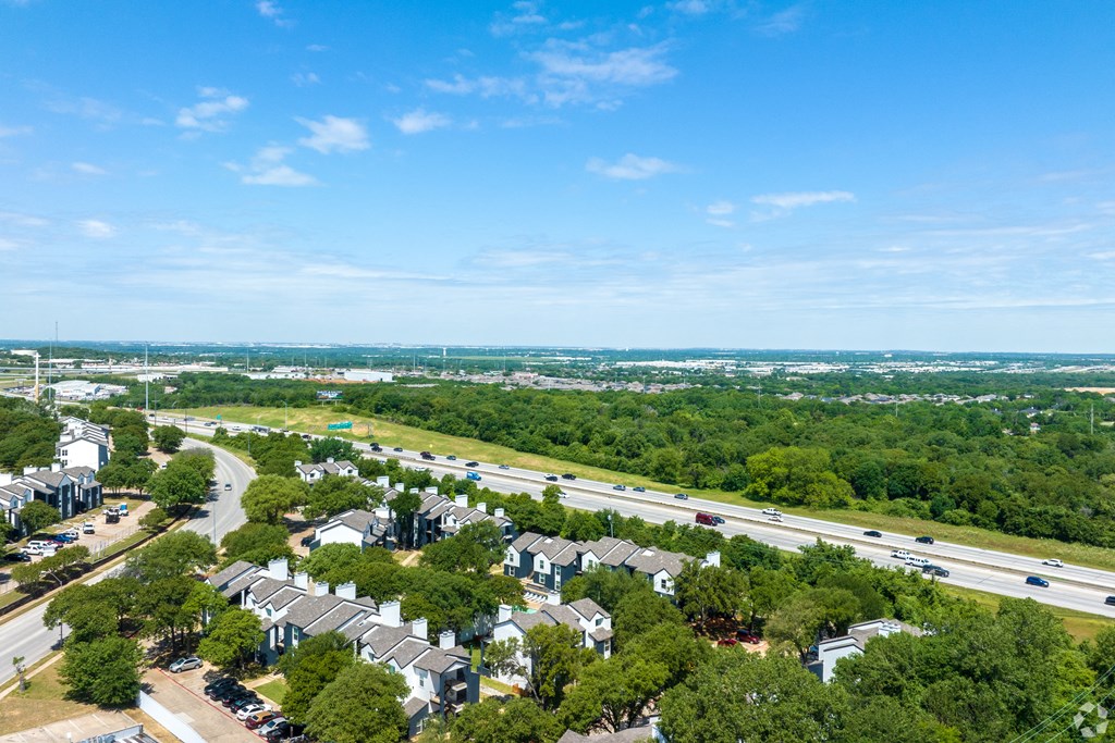 an aerial view of a neighborhood with a highway and trees