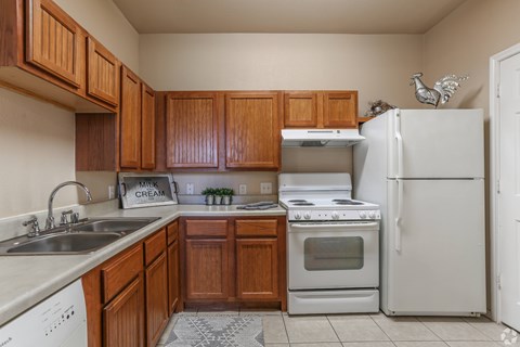 A kitchen with wooden cabinets and white appliances.