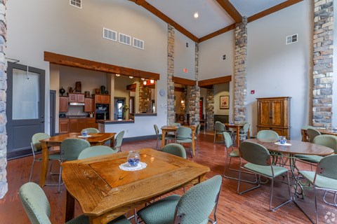 A dining room with a wooden table surrounded by chairs.