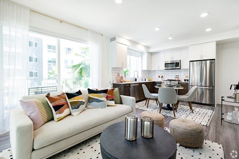 A modern living room with a white sofa and a black coffee table.