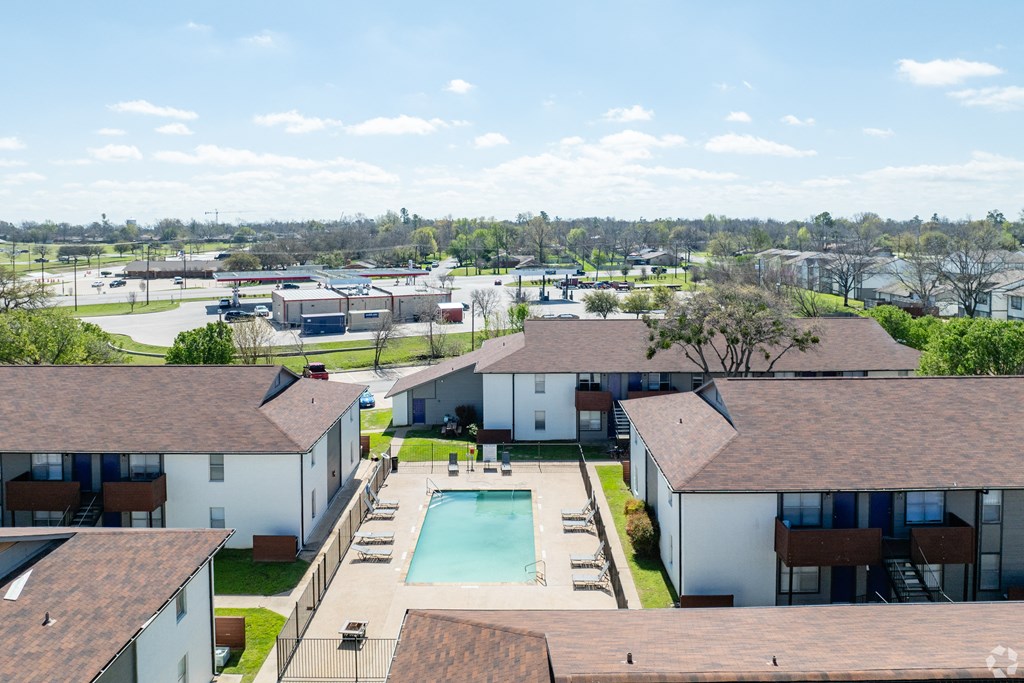 an aerial view of a neighborhood of houses with a swimming pool