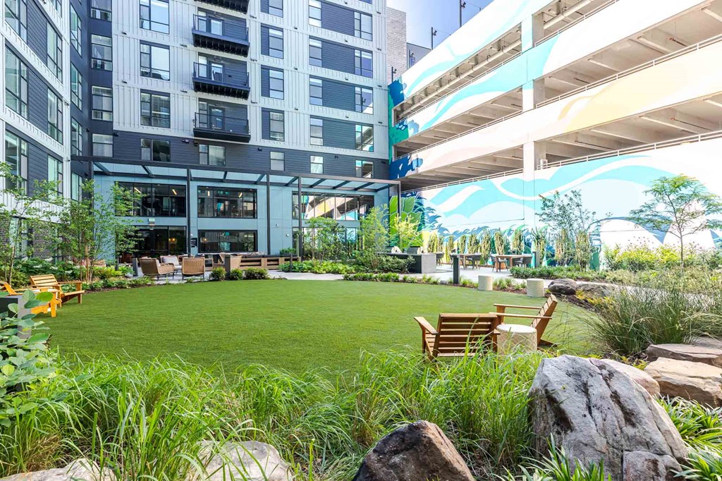 A modern building with a green space in front of it.