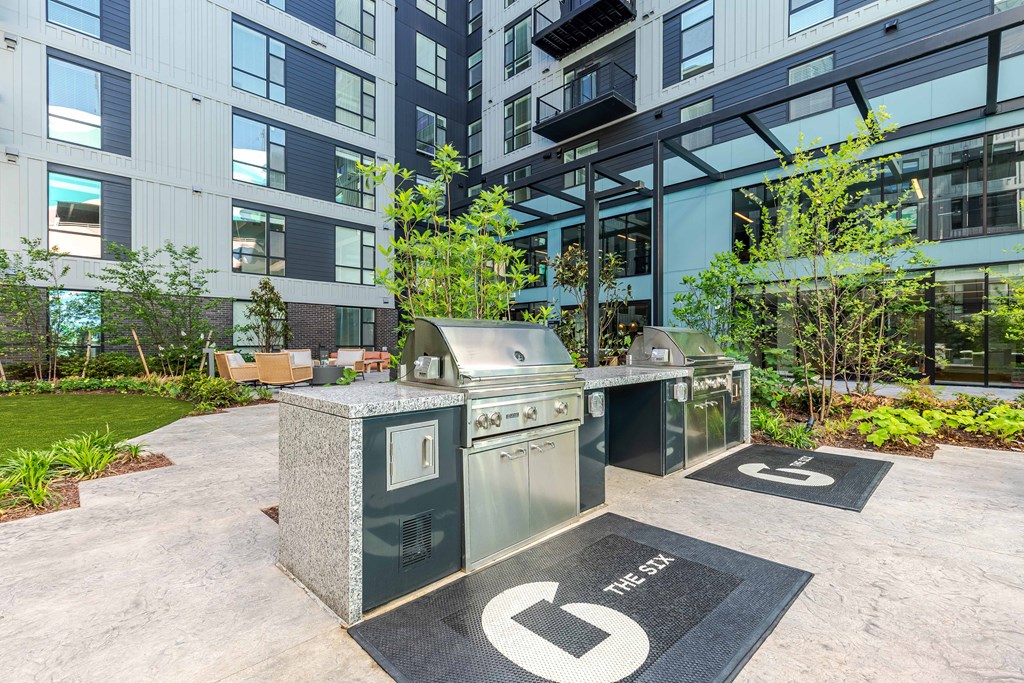 A modern outdoor kitchen area with a grill and sink.