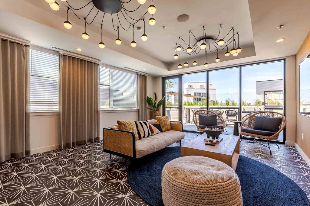 A living room with a patterned carpet and a large window.