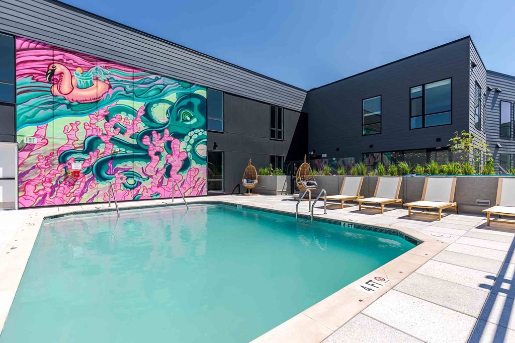 A pool with a mural on the side of a building.