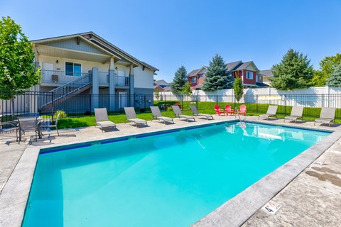 A swimming pool in a residential area with houses in the background.