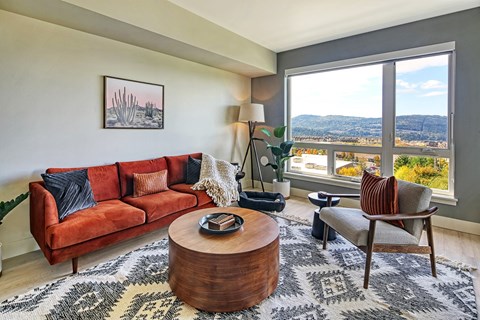 a living room with a red couch and a large window