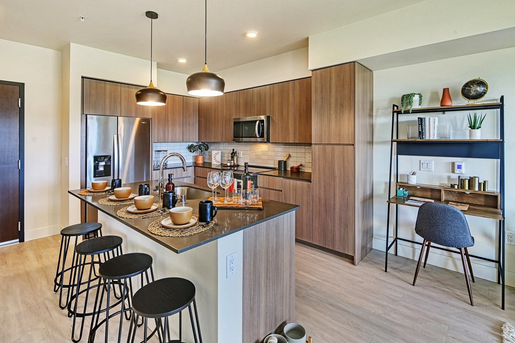 a kitchen with wooden cabinets and a large island with a breakfast bar