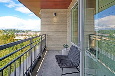 a balcony with a chair and a potted plant