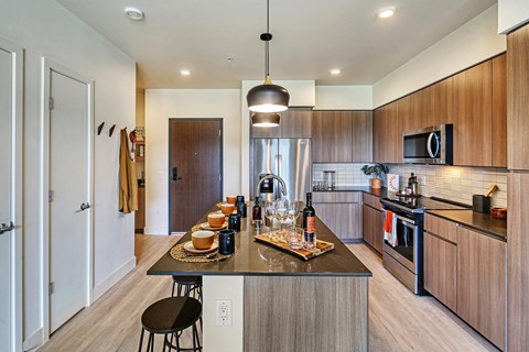 a kitchen with wooden cabinetry and a large island with a breakfast bar