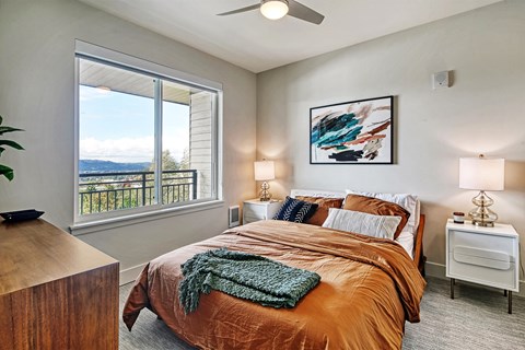 a bedroom with a large window and a large bed