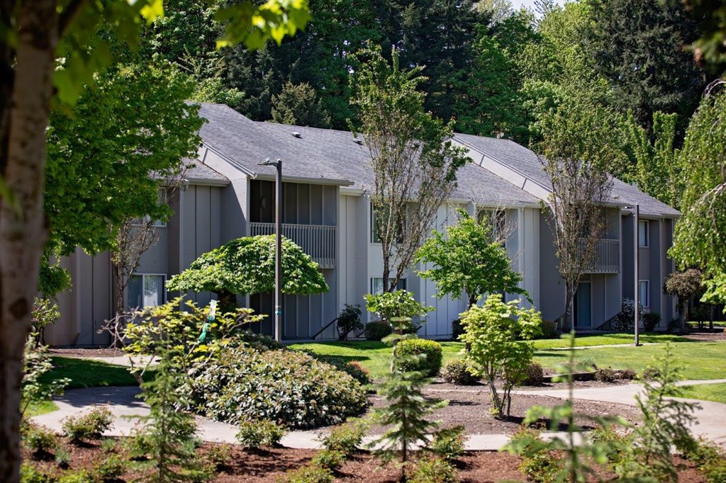 a group of houses with trees and bushes in front of them