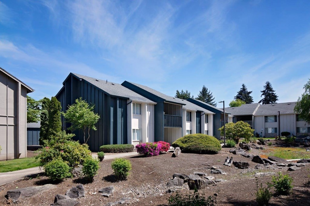 a group of houses in a row with a rock garden in front of them