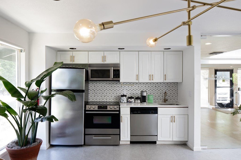 a kitchen with white cabinets and black appliances