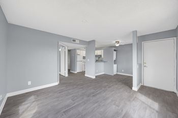 A spacious room with grey walls and wooden flooring.