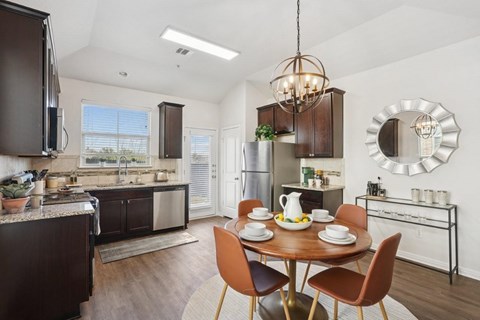 A modern kitchen with a dining table set for two.