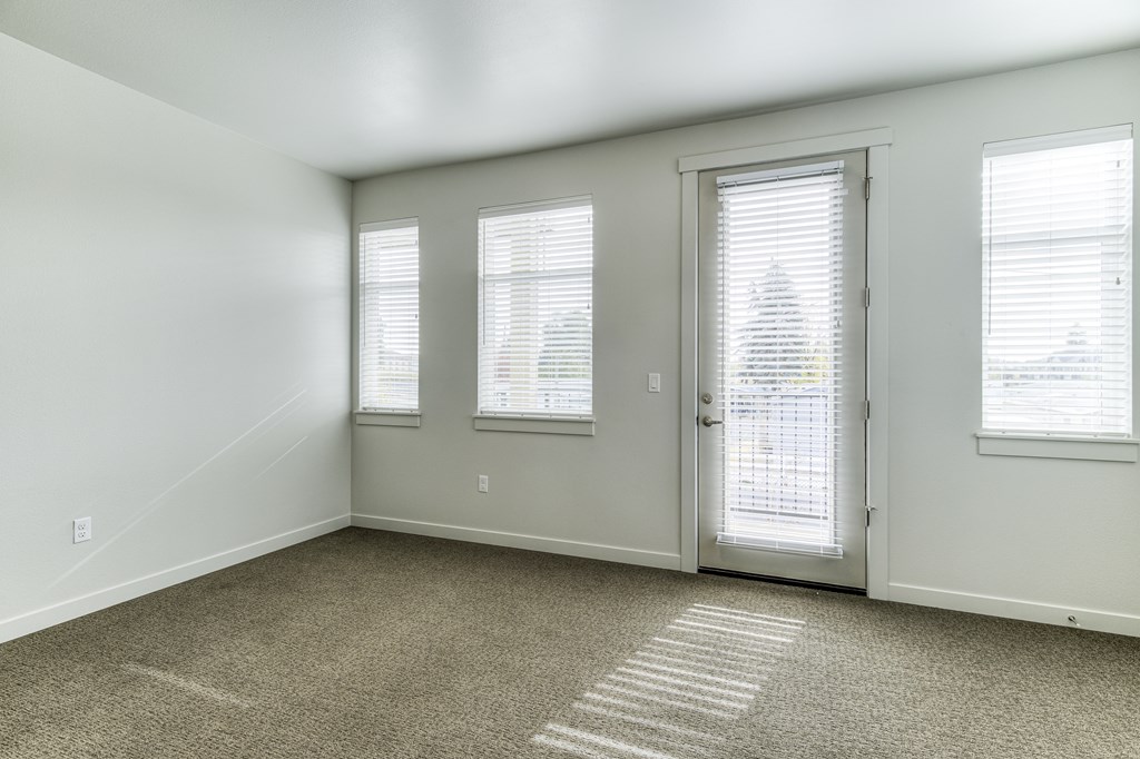 A room with a carpeted floor and a door with a window on the side.