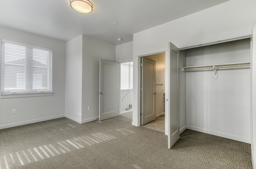 A room with a carpeted floor and a sliding door.