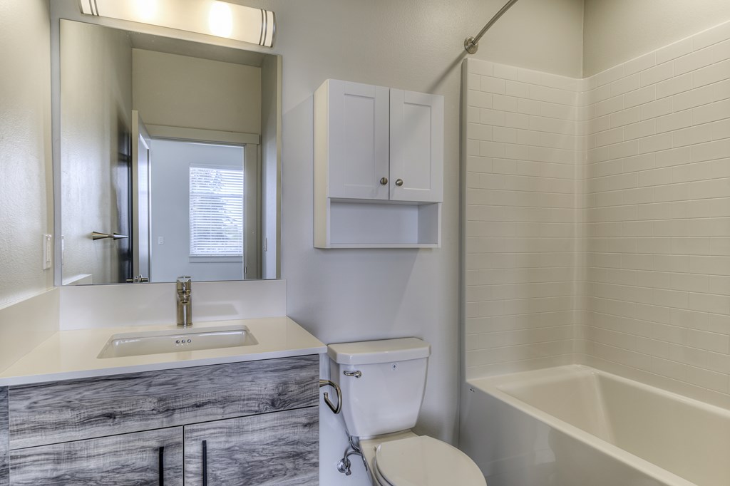 A white bathroom with a sink, toilet, and bathtub.