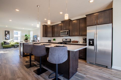 a kitchen with a center island and a stainless steel refrigerator