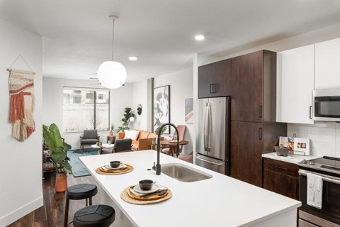 a kitchen and living room with a white counter top