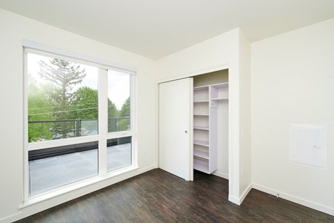 a bedroom with a large window and a closet
