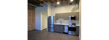 A kitchen with a refrigerator, sink, and oven.