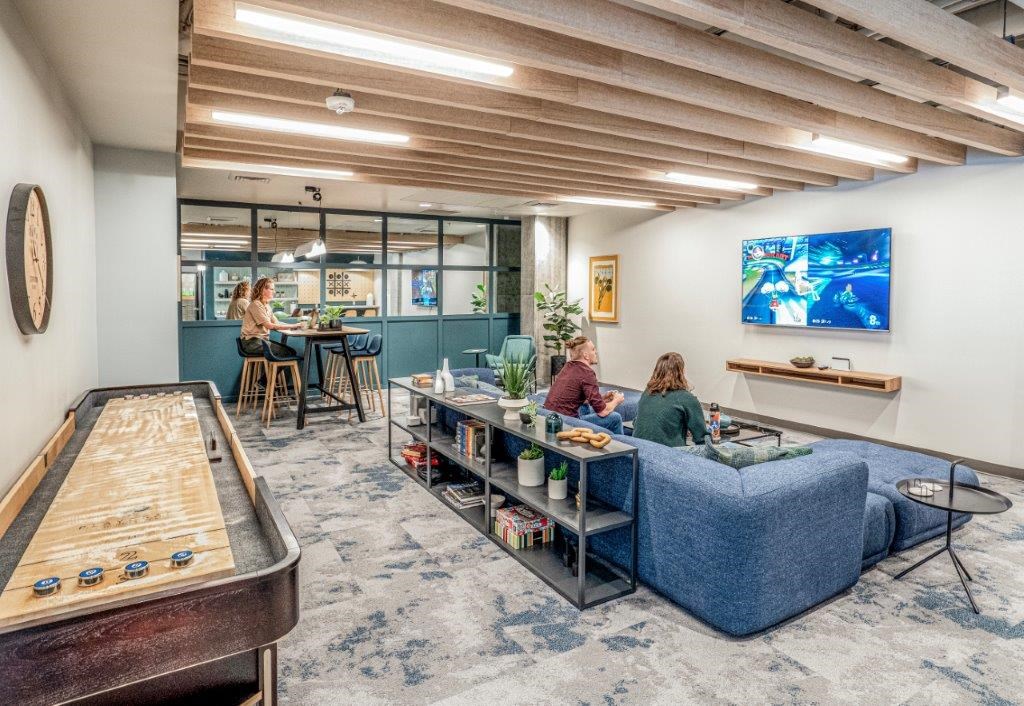 people sitting on a couch in a room with a pool table