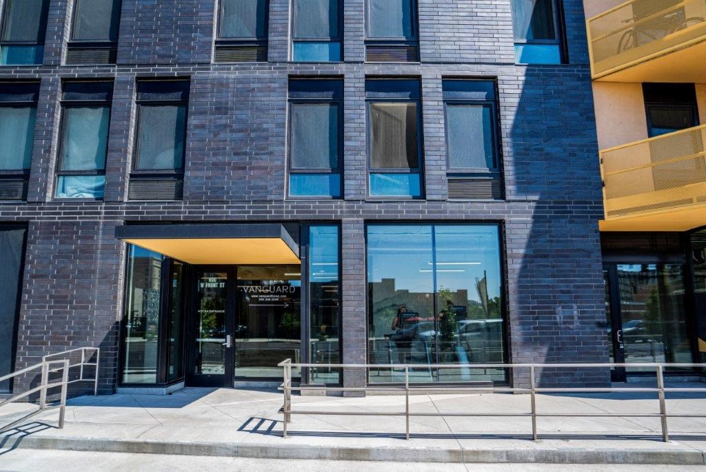 a brick building with a glass front door and stairs